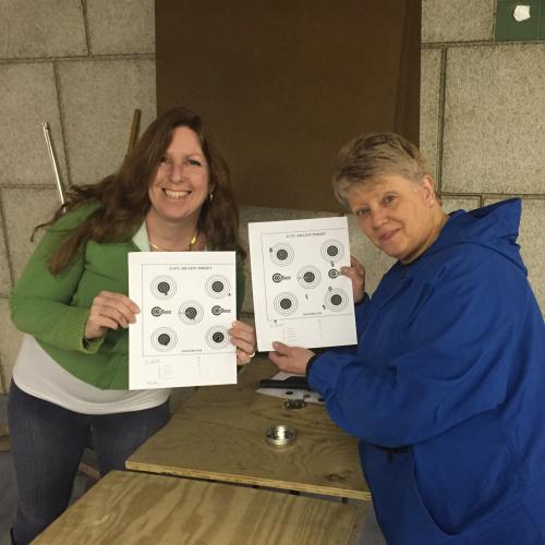 Two rod and gun club members showing off their rifle targets.